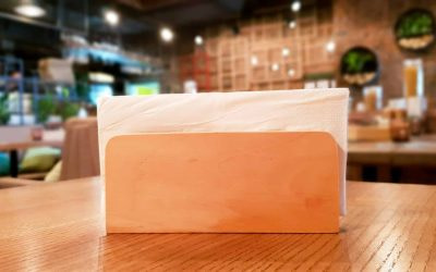 A table in a cafe or restaurant. White napkins in a wooden napkin holder, panoramic view.